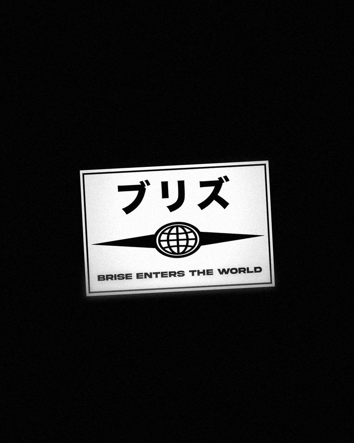 Woven patch with the Japanese lettering ブリズ, a globe emblem and the text BRISE ENTERS THE WORLD